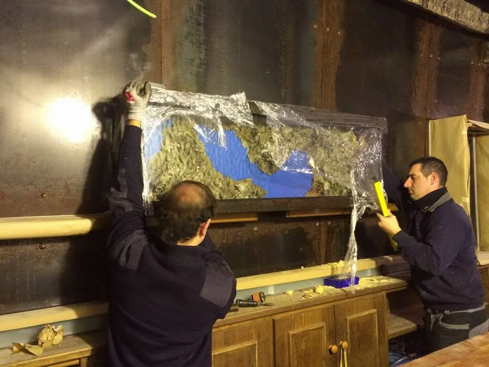 Dos personas colocan un panel decorado de un vivero durante su instalación