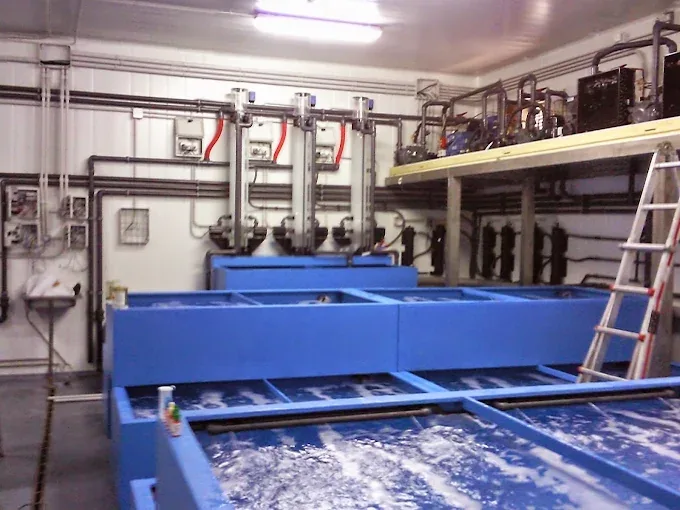Depósitos azules conectados a tuberías y equipos de un circuito de agua